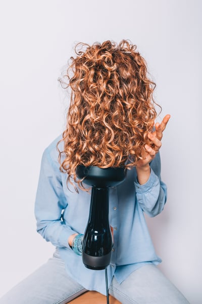 curly hair girl using a diffuser